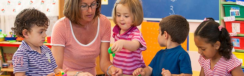 Educator with early childhood students in a classroom setting